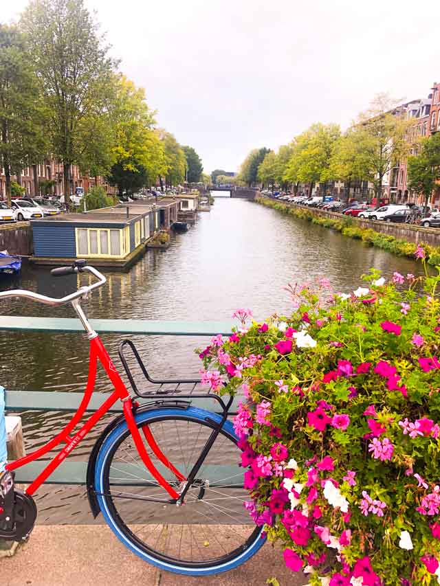 Bike e canal de Amsterdam cheio de flores